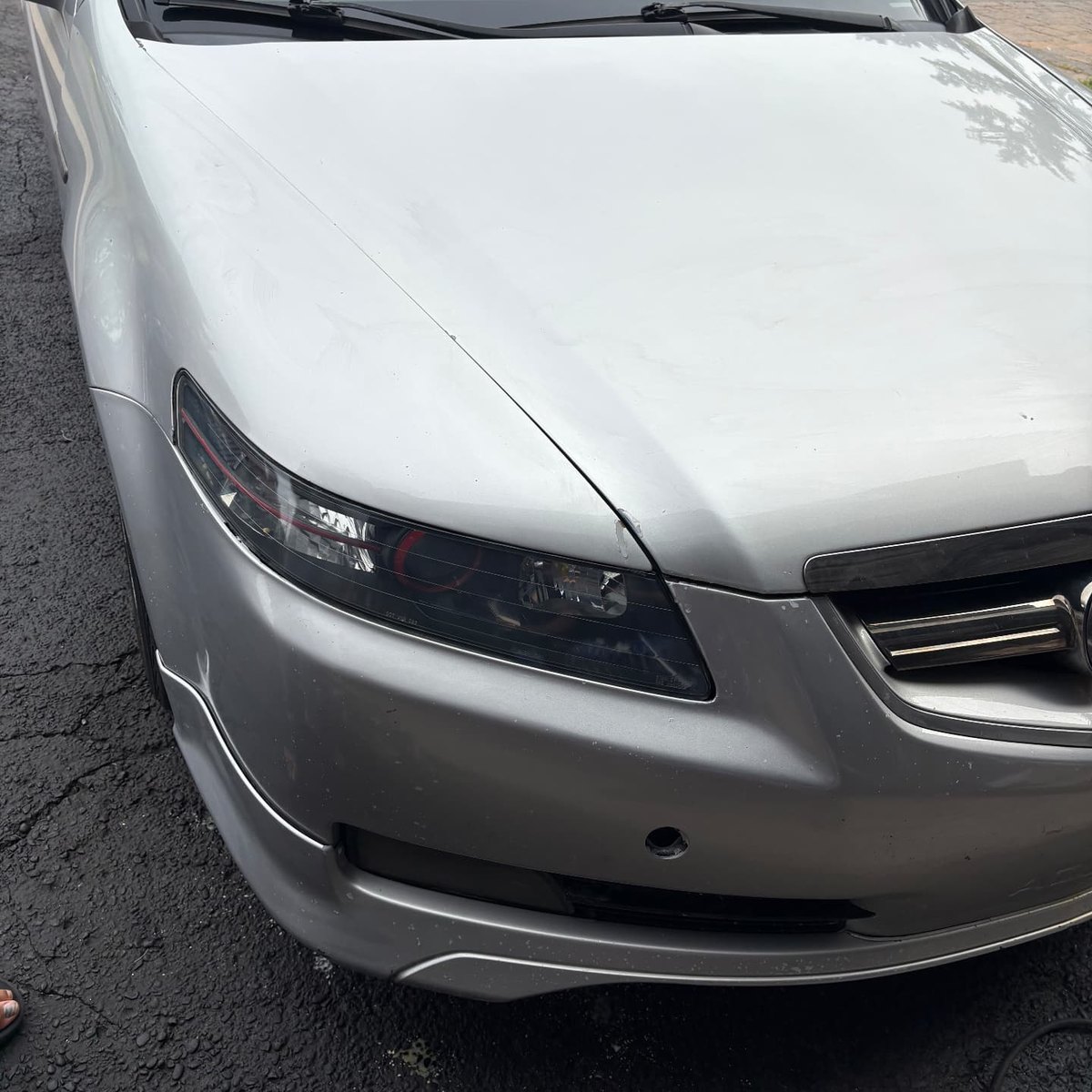 Clear driver side headlight on a silver Acura TL after restoration